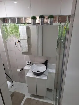 a bathroom with a toilet and a sink with plants at Cosy Cottage Cape Town in Cape Town