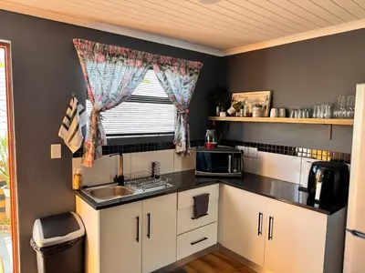 a small kitchen with a sink and a window at Ocean Breath Apartment in Strand