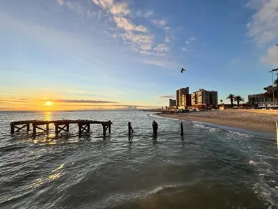a group of people standing in the water near the beach at Ocean Breath Apartment in Strand