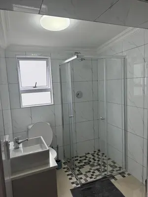 a bathroom with a shower and a toilet and a sink at Canary Guest house in Cape Town