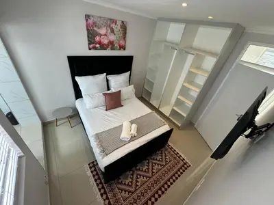 a small bedroom with a bed and a piano at Canary Guest house in Cape Town