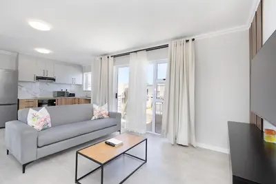a living room with a couch and a table at Elegant apartment near beach in Cape Town