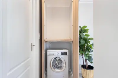a laundry room with a washer and dryer in a closet at Elegant apartment near beach in Cape Town