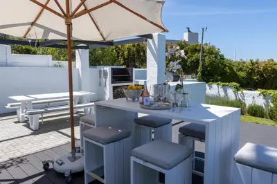 a table and chairs with an umbrella on a patio at Waveren's Nest in Cape Town