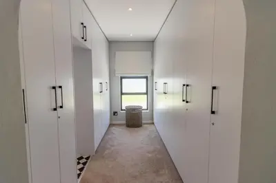 a hallway with white cabinets and a trash can at Waveren's Nest in Cape Town