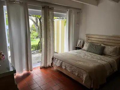 a bedroom with a bed and a large window at Voëlklip Holiday Home in Hermanus