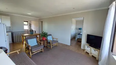 a living room with two chairs and a television at 45 on Luke in Hermanus