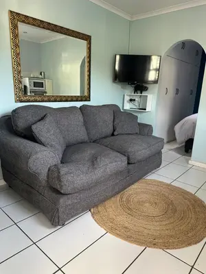 a gray couch in a living room with a mirror at Casa on Alamein in Cape Town