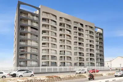 a large building with cars parked in front of it at BEACHFRONT Breeze in Cape Town