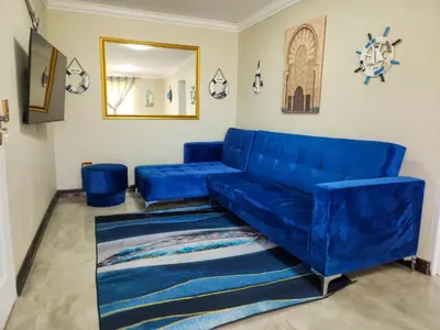 a blue couch in a living room with a mirror at The Seagull in Cape Town