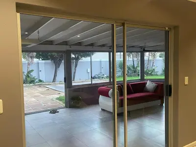 a living room with glass doors and a red couch at Zoe & Saint in Cape Town