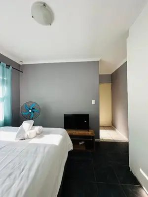 a bedroom with a white bed and a desk at Zoe & Saint in Cape Town