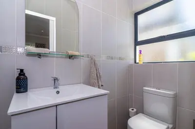 a bathroom with a sink and a toilet and a window at SeaB by Top Destinations Rentals in Hermanus