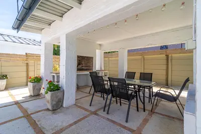 a patio with a table and chairs on it at SeaB by Top Destinations Rentals in Hermanus
