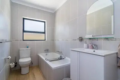 a white bathroom with a toilet and a sink at SeaB by Top Destinations Rentals in Hermanus