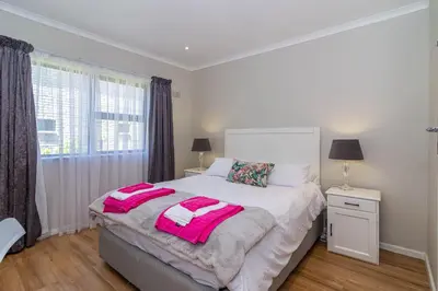 a bedroom with a bed with pink towels on it at SeaB by Top Destinations Rentals in Hermanus