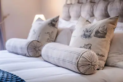 a white bed with pillows on top of it at Village Artisan Franschhoek in Franschhoek
