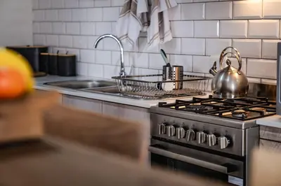 a kitchen with a stove with a tea kettle on it at Village Artisan Franschhoek in Franschhoek