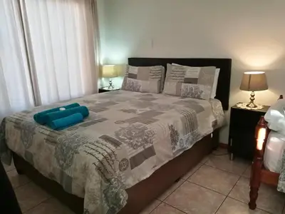 a bedroom with a bed with a blue pillow on it at Getaway Self-Catering Panorama in Panorama