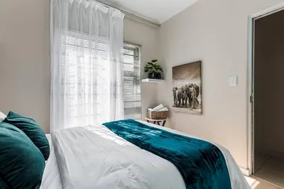 a bedroom with a bed and a window at The Greenfields Suite in Cape Town