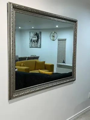 a mirror reflecting a living room with a yellow couch at JDBA Homes of Luxury in Cape Town