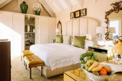 a bedroom with a bed and a table with a bowl of fruit at Birkenhead House in Hermanus