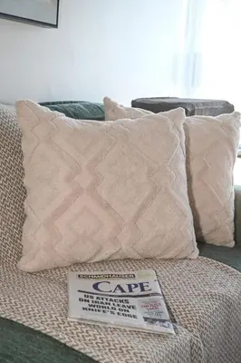 a pillow with a care sign sitting on a bed at Unwind at Coral 2BR Bloubergstrand Beach Apt Walk to Beach in Bloubergstrand