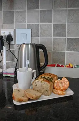 a plate of bread and a cup of coffee on a counter at Unwind at Coral 2BR Bloubergstrand Beach Apt Walk to Beach in Bloubergstrand