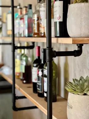 a shelf with bottles of wine on it at YEBO Boutique Guesthouse in Somerset West