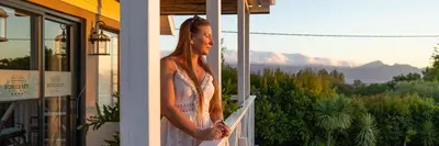 a woman standing on a balcony looking out of a window at YEBO Boutique Guesthouse in Somerset West