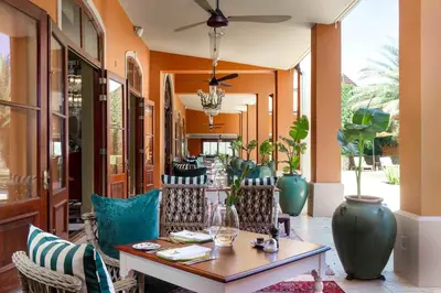 a patio with a table and chairs and vases at La Residence in Franschhoek