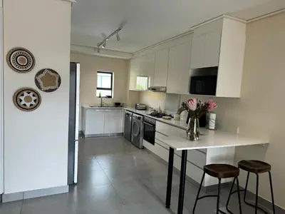 a kitchen with a counter and a table with chairs at 111 at The Esplanade in Hermanus