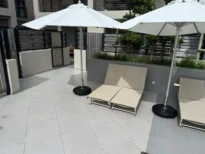 two chairs and an umbrella on a patio at 111 at The Esplanade in Hermanus