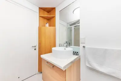 a bathroom with a white sink and a shower at Horizon Bay 202 Beachfront APT, Bloubergstrand in Cape Town