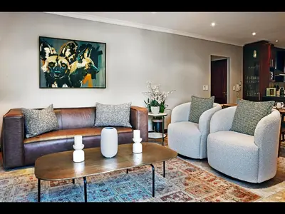 a living room with a couch and two chairs and a table at Sorbonne 6 in Franschhoek