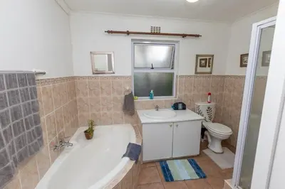a bathroom with a tub and a sink and a toilet at 3 Bedroom part house in the scenic Durbanville wine lands area, holiday facility in Cape Town