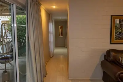 a hallway of a house with a couch and a window at 3 Bedroom part house in the scenic Durbanville wine lands area, holiday facility in Cape Town