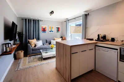 a kitchen and living room with a couch at Von Chambers Blouberg in Cape Town