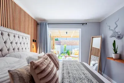 a bedroom with a bed and a large window at Von Chambers Blouberg in Cape Town