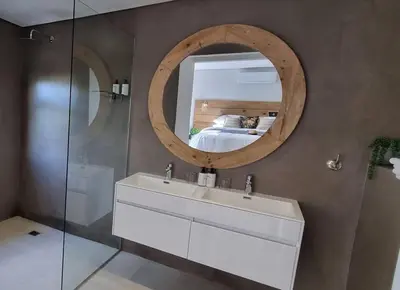 a bathroom with a sink and a mirror and a bed at C'est la Vie 5 Garden View Apartment in Franschhoek