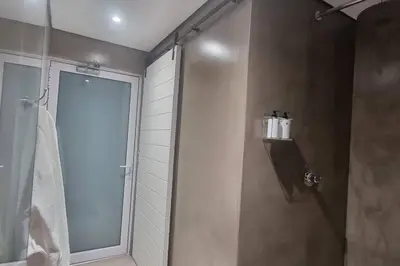 a shower with a glass door in a bathroom at C'est la Vie 5 Garden View Apartment in Franschhoek