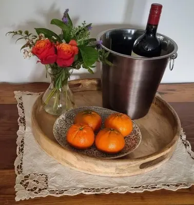 a bowl of oranges and a vase of flowers and a bottle of wine at C'est la Vie 5 Garden View Apartment in Franschhoek
