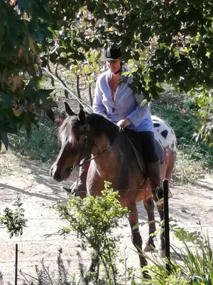 a man riding a horse down a dirt road at The GOAT shed in Paarl