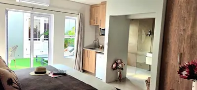 a living room with a couch and a kitchen at C'est la Vie 6 Standard Apartment in Franschhoek