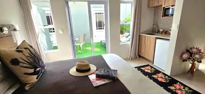 a hat sitting on top of a bed in a room at C'est la Vie 6 Standard Apartment in Franschhoek