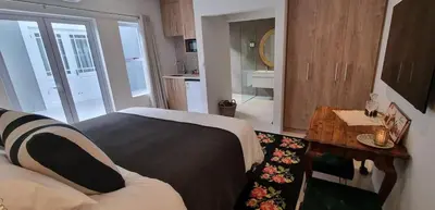 a small room with a bed and a small kitchen at C'est la Vie 6 Standard Apartment in Franschhoek