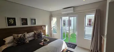 a bedroom with a large bed and a sliding glass door at C'est la Vie 6 Standard Apartment in Franschhoek