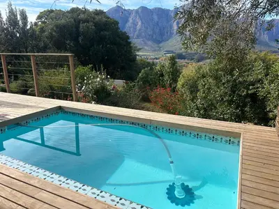 a large swimming pool with a water fountain in it at Zeven Eike Homestead in Stellenbosch