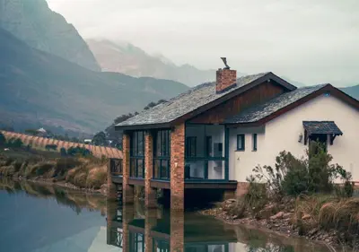 a house on the side of a river at Wildeberg Dam House Cottage in Franschhoek