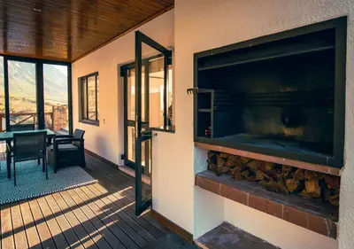 a balcony with a large fireplace on a house at Wildeberg Dam House Cottage in Franschhoek